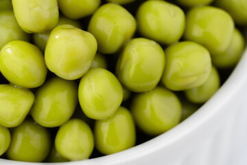 Fresh green peas background, texture of perfect peeled sweet pea grains as background. Vegetable background, vegetable protein, healthy products. Canned peas.