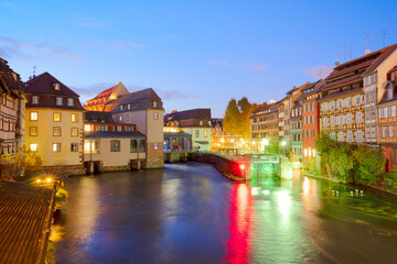 canal gateway and old houses of Petit France medieval district of Strasbourg illuminated at night, France , retro toned