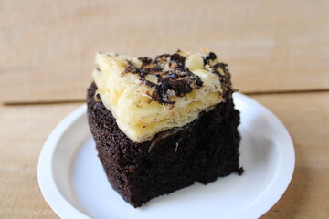 A slice of layered chocolate cake with crispy puff pastry topping