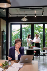 Asian Woman Working on Laptop in Modern Office Space Concentrating on Work Career Success Business Meeting Coworking Strategy Discussing Ideas