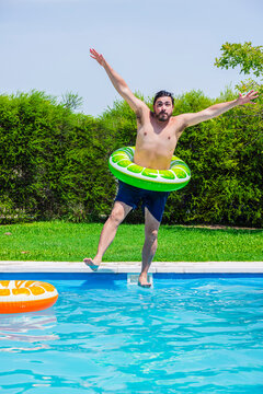 Mid adult man diving into a pool with a float during summer in Argentina