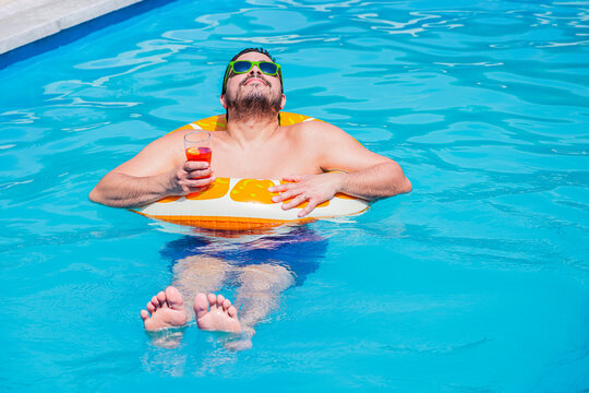 Man relaxing on a pool float with a drink in Argentina