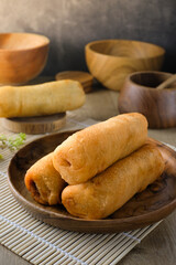 Traditional Asian molen snack, fried banana pastry on wooden plate, rustic background, perfect for culinary, food blog, recipe illustration, traditional dessert, bakery, or snack content