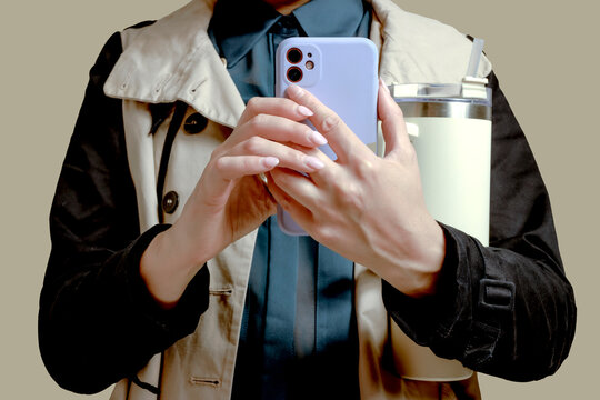 Cropped view of a person holding a smartphone and a water thermos