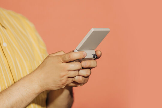 Mid adult man playing with a retro style portable gaming console indoors