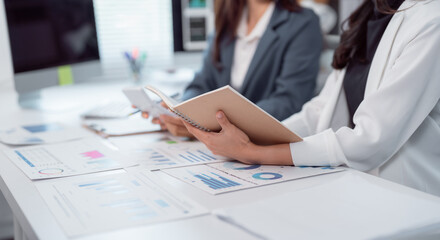 Business team working with financial data analyzing charts and graphs, calculating and taking notes...