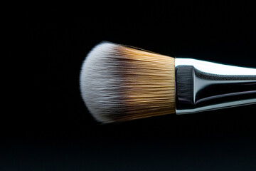 Fototapeta premium Close-up of a makeup brush applying vibrant eyeshadow during a beauty routine