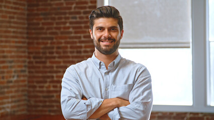 Portrait Of Smiling Businessman In Office Standing By Window