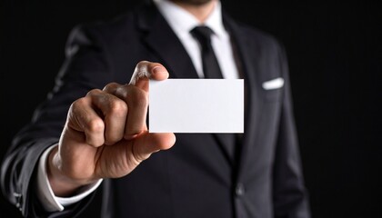 Office worker holding a horizontal business card, black background, strict business style, focus on hands and card.