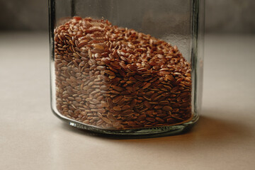 Organic brown rice stored in a glass jar with earthy tones and textures