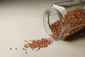 Brown rice tumbling from a glass jar onto a clean surface