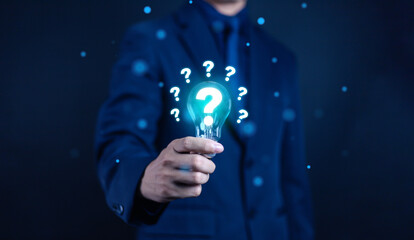 Businessman showing question mark, concept of asking, answering, business FAQ, thinking and wondering, brainstorming and problem solving.
