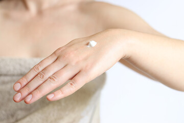 Fototapeta premium Hand cream. Close-up of young woman's hand with moisturizing cream. Skin care. Close-up of female hands applying cream to skin. Healthy skin, skin care concept. Cosmetology. Daily routine