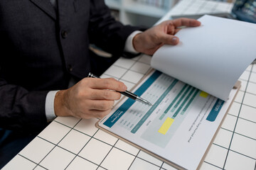 a businessman is sitting at work in his private office, an employee is handling documents to finish on time, accountant, finance, statistics documents, professional, workplace
