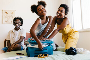 Excited family packing a suitcase together for a fun vacation
