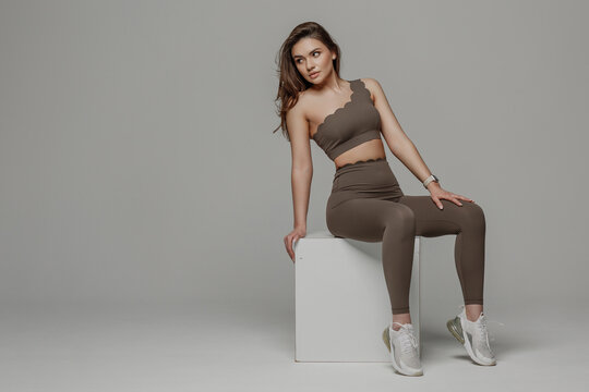 Sporty woman posing in fitness studio wearing fashionable activewear for a stylish fitness shoot