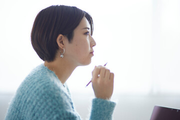 ノートパソコンで勉強をする若い日本人女性