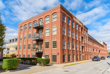 Historic brick warehouse renovatd and converted into apartment lofts under blue sky on a sunny autumn day