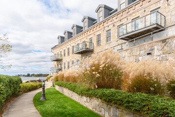 Stone apartment building along a deserted narrow footpath leading to a harbour on a cloudy autumn day