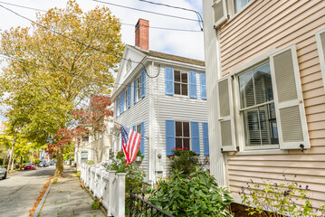 Historic wooden houses along a tree lined street in a old town centre in New England on a sunny autumn day