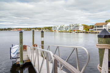 Empty wooden armchairs on a floating jetty on a river on a cloudy autumn day