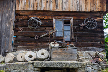 Old wooden house with millstones and antique tools hanging in Sekowa, Poland