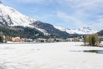 Apartment buildings on the shore of frozen lake St. Moritz on an early spring day. Canton of Grisons, Switzerland.