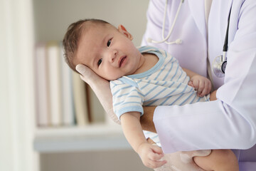 Doctors are gently vaccinating a boy in a clinic to ensure that the baby is healthy, protected and...