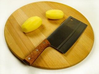 Raw whole potatoes and kitchen knife  on a cutting board, prepare for cooking food