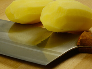 Raw whole potatoes and kitchen knife  on a cutting board, prepare for cooking food
