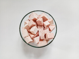 Taro, sliced of taro in a bowl. Fresh taro cubes in a bowl on white background. Food ingredients. Copy space. 