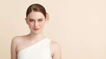 A beautiful young woman with clean, fresh skin against a beige background. Skincare, facial treatment, cosmetology, beauty, and spa. An elegant portrait of an woman.