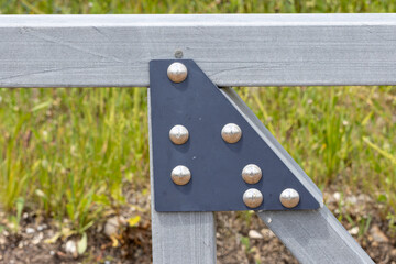 Metal bracket reinforcing wooden beam in outdoor setting