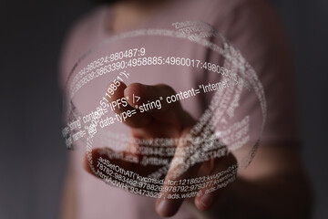 Close-up of a person's hand interacting with a digital sphere of code.