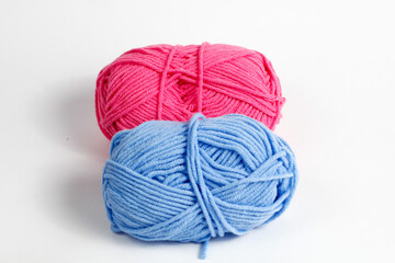 Pink and blue wool thread neatly rolled into an oval shape isolated on a white background
