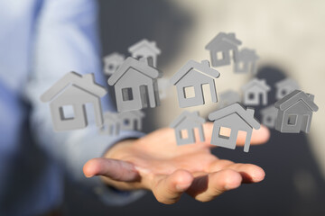 Image of a hand holding multiple digital house icons, ideal for real estate, property, and home concepts.