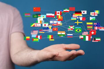 Hand holding interconnected flags, representing international collaboration and global connections.