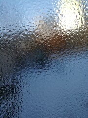 Frosted glass window with blurred landscape view on winter day  