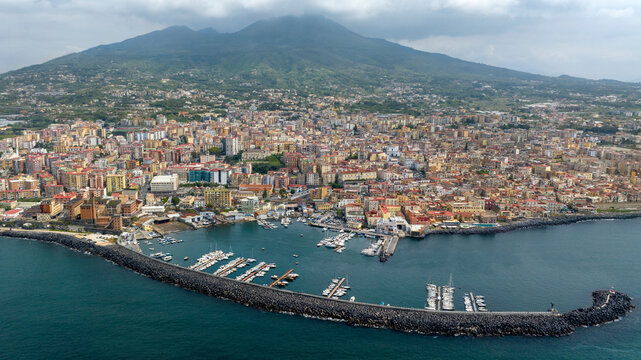 Aerial view of the city of Torre del Greco in the province of Naples, Campania, Italy. There is Mount Vesuvius in the background and the port of the town in the foreground.