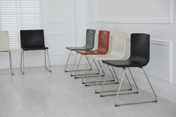 Fototapeta premium Colorful chairs near white wall in waiting room