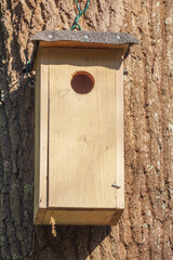 Vogelhaus aus Holz an einem Baumstamm hängend , Deutschland