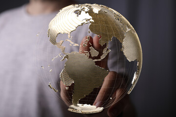 Person's finger interacts with a digital globe, symbolizing global connections and networking.