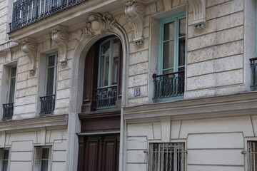 Obraz premium Ornate Parisian Facade with Arched Doorway, Light Blue Windows, and Number 13
