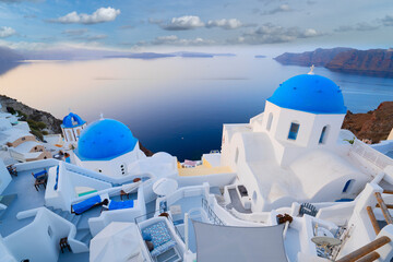 traditional greek village Oia of Santorini, with blue domes of churches and village roofs, Greece