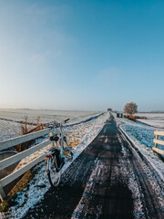 A frozen country road specific to rural Holland during a frosty winter. Walking path along the famous Dutch canals and windmills