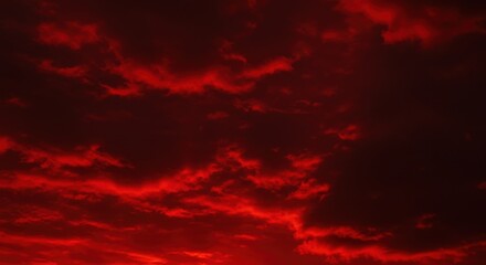 Dramatic red sky filled with dark, ominous clouds creating a fiery and intense atmosphere at sunset