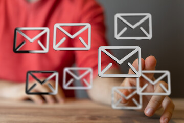 Person interacting with email icons, showcasing inbox management and digital communication.