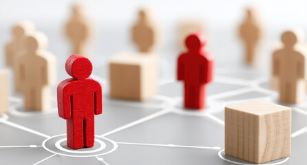 Red figure connected in network among wooden figures emphasizing communication concepts