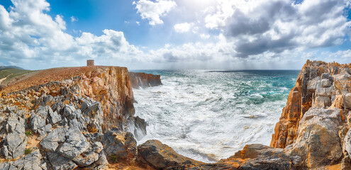 Unbelivable view of cliffs in valley Cala Domestica  with old tower and storm on the sea.
