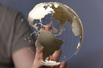 High-quality stock photo of a hand holding a digital 3D model of the Earth, representing global...